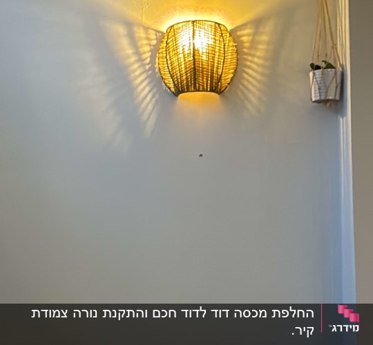 מנורת קיר דולקת על קיר לבן